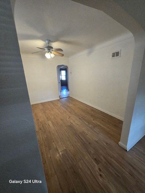 a living room with a ceiling fan and wood flooring