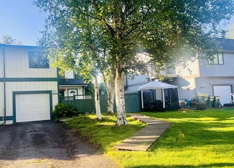 a house with a yard and a tree in front of it