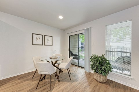 A dining room with a glass table and chairs.