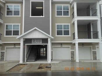 an empty garage door in front of an apartment building