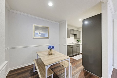 A dining table with a vase of blue flowers on it.