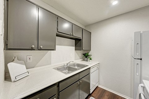 A kitchen with a white counter top and stainless steel appliances.