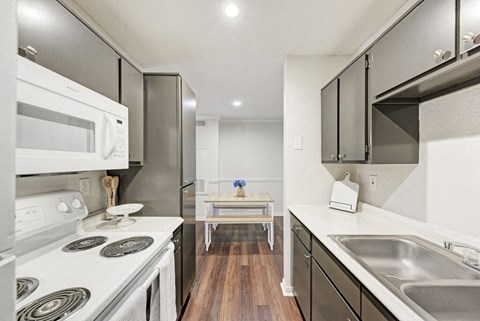A modern kitchen with a white stove top oven and a white microwave.