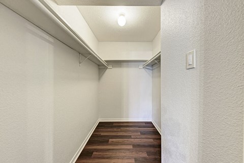 A long, narrow hallway with wood flooring and white walls.