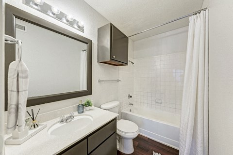 A white bathroom with a toilet, sink, and shower.