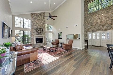 A living room with a stone fireplace and wood floors.