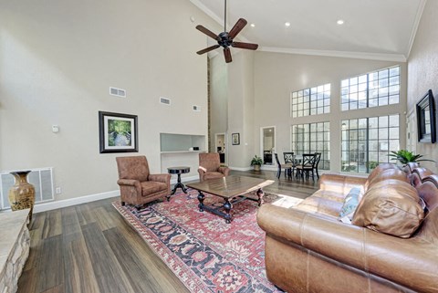 A living room with a brown leather couch and a rug.
