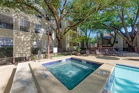 A pool surrounded by trees and a building with a sign that says "Northwoods".