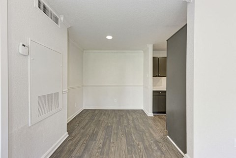 A room with a white wall and a wooden floor.