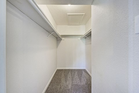 A long, narrow hallway with a carpeted floor and white walls.