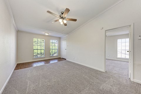 A room with a ceiling fan and carpeted floor.