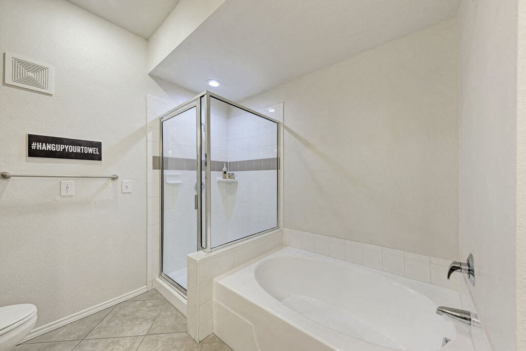 A bathroom with a white tub and a glass shower door.