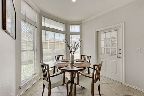 A dining room with a table set for four.