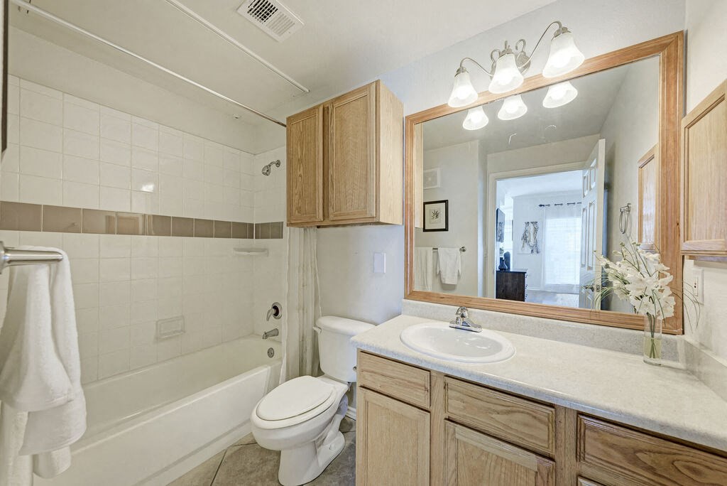 A white toilet sits next to a white sink in a bathroom.