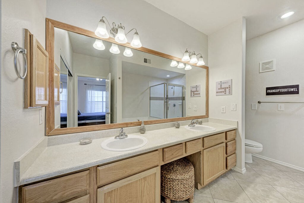 A bathroom with a large mirror and a white sink.