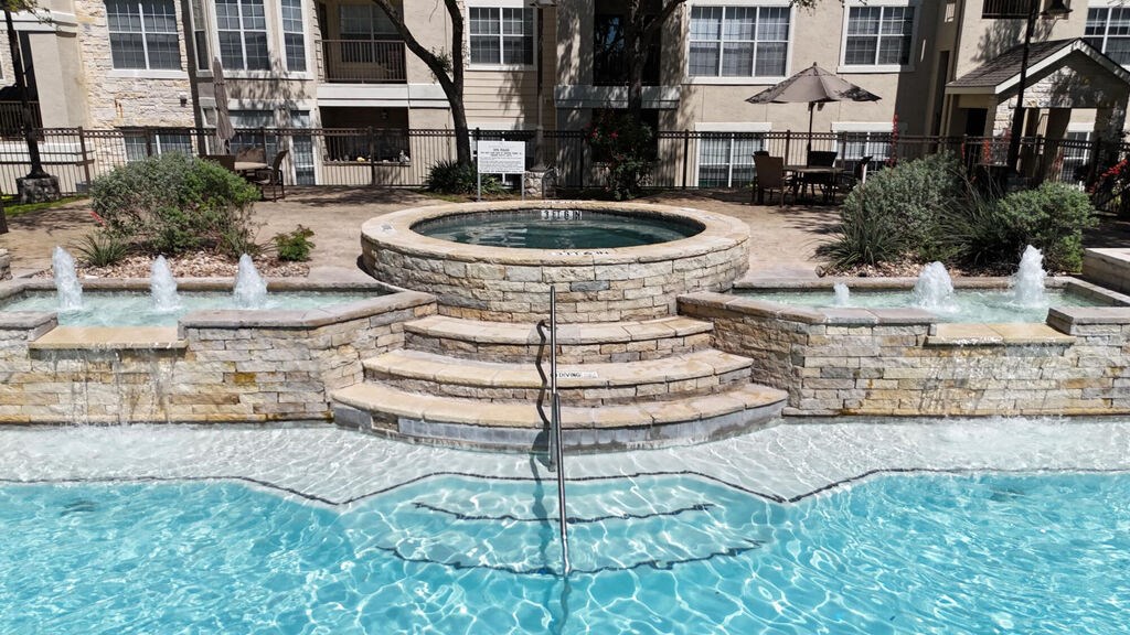 A pool with a fountain in the middle of it.