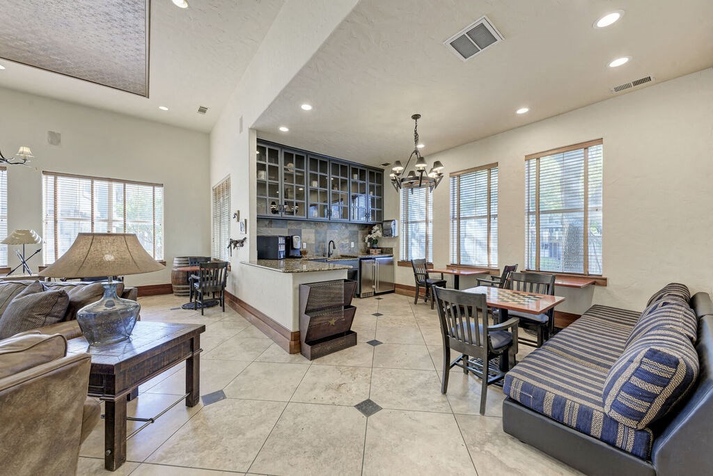 A well-lit, spacious living room with a kitchen area in the background.