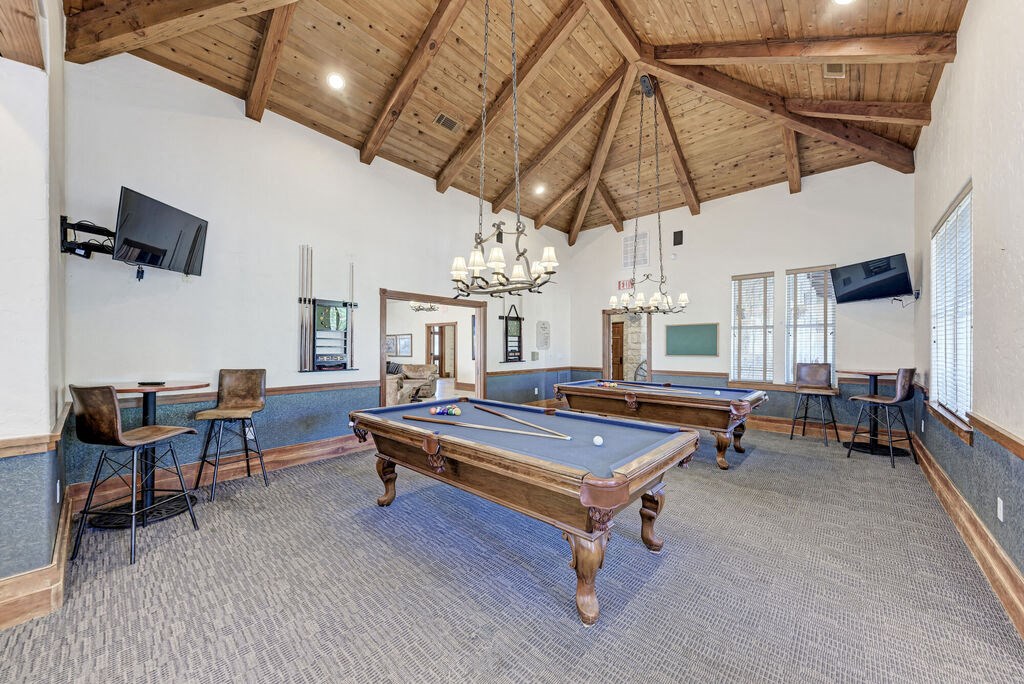 A room with a pool table and a television.