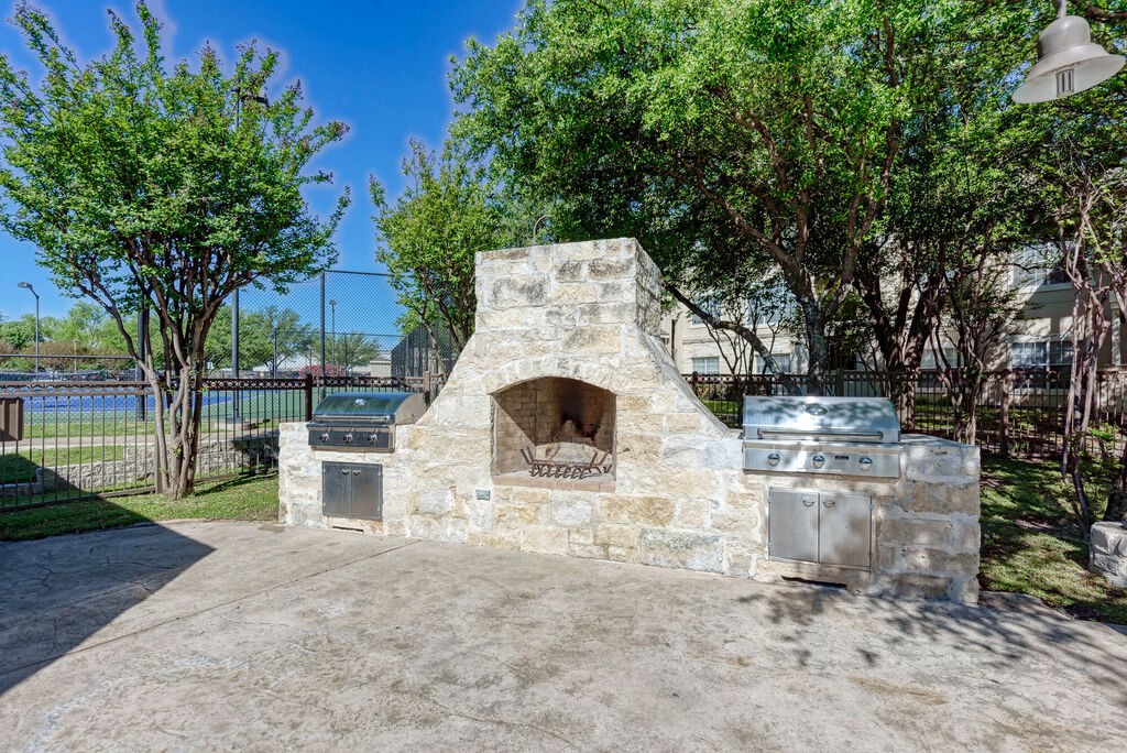 A stone oven is in the middle of a cement area.
