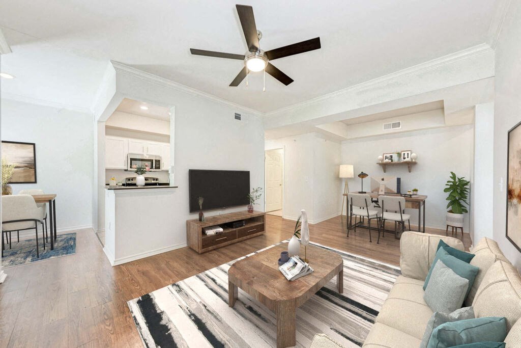 A living room with a white ceiling fan and a wooden coffee table.