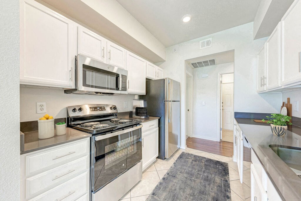 A kitchen with white cabinets and stainless steel appliances.