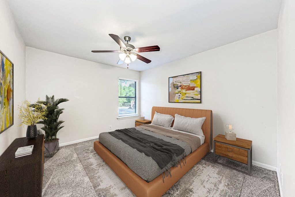 A bedroom with a bed, nightstand, and a ceiling fan.