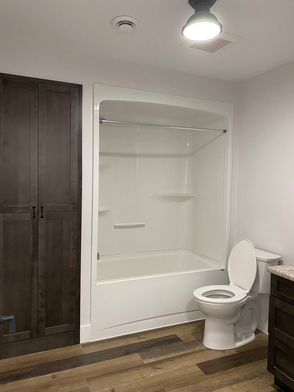A white toilet sits next to a walk-in shower in a bathroom.