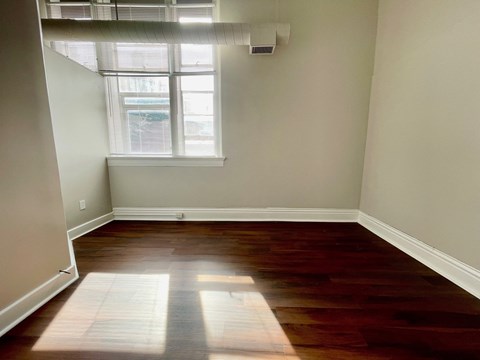 A room with a window and a white wall.