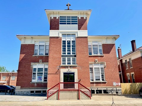 A red brick building with a cross on top.