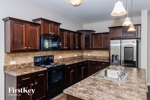 a kitchen with dark wood cabinets and granite counter tops