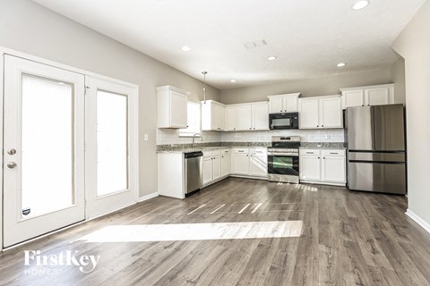A modern kitchen with white cabinets and stainless steel appliances.