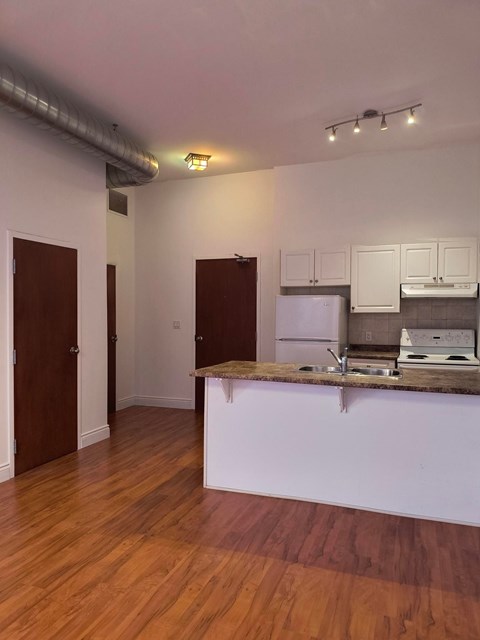 A kitchen with a white counter and a fridge.