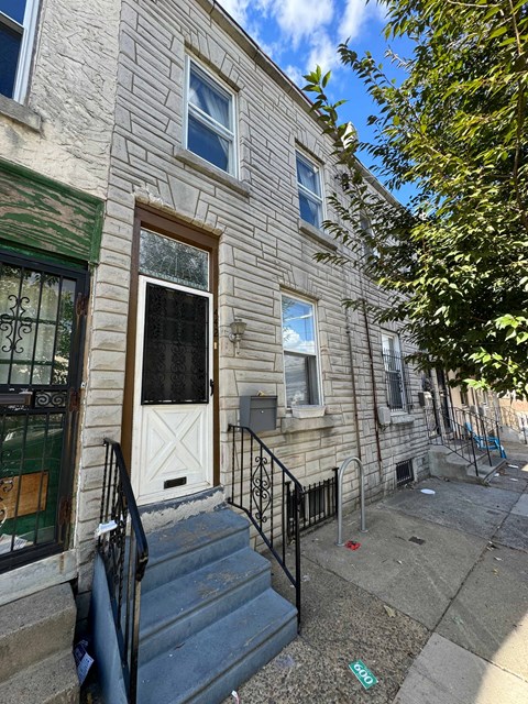 the front of a building with stairs and a white door