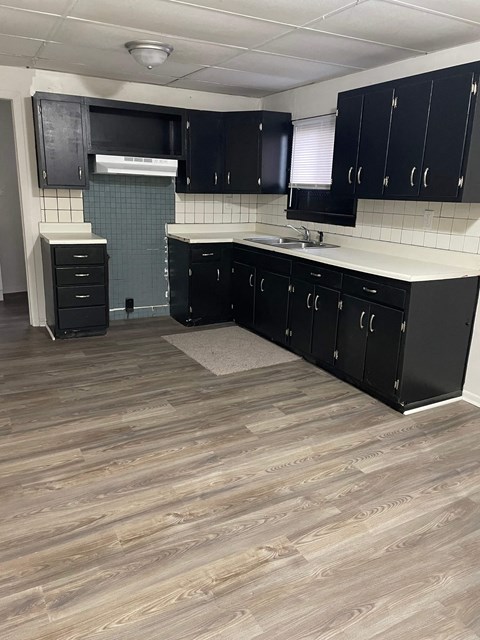 A kitchen with black cabinets and a white countertop.