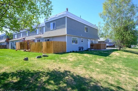 a white house with a yard and a wooden fence