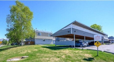 a car dealership with a car parked under a roof