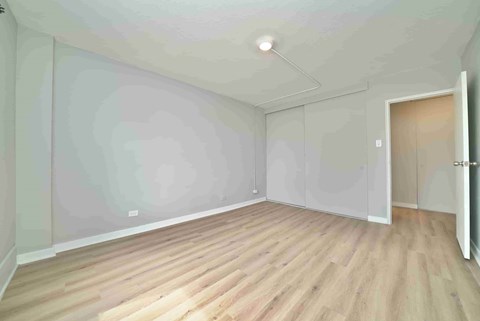 A room with wooden flooring and white walls.