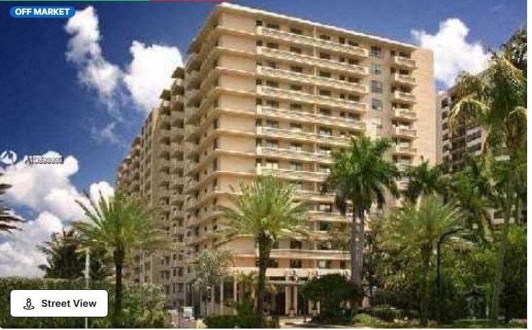 an image of an apartment building with palm trees