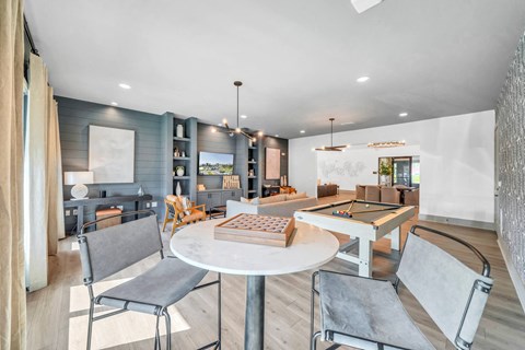 A modern living room with a pool table and a dining table.