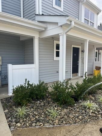 A house with a grey siding and a white door.