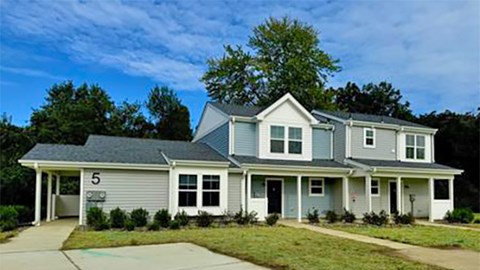 House number 5 is a two story home with a garage.