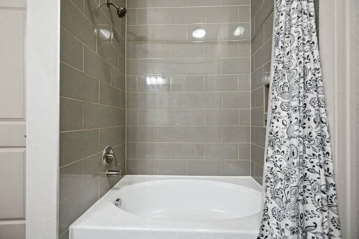 a bathroom with a white tub and a shower curtain