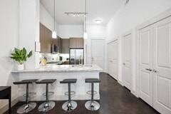 a white kitchen with a bar and stools