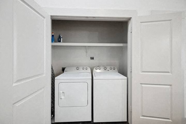 a white closet with two white washer and dryers
