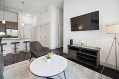 a living room with a table and a kitchen