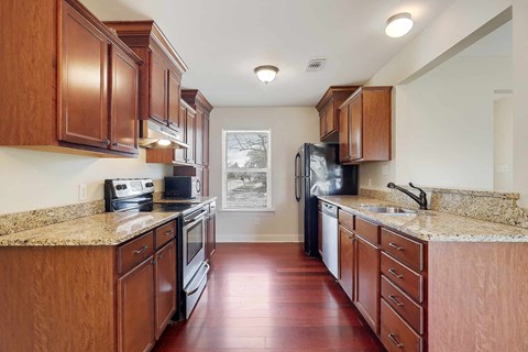 A kitchen with wooden cabinets and a black fridge.