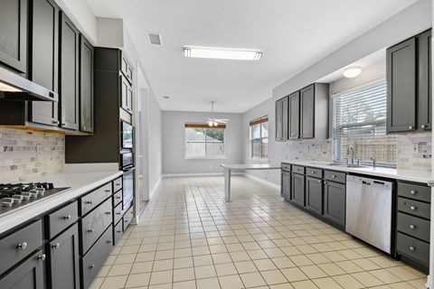 A kitchen with black cabinets and white appliances.