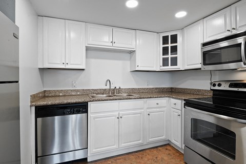 A kitchen with white cabinets and stainless steel appliances.