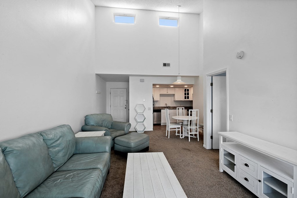 A living room with a couch, chairs, and a dining table.