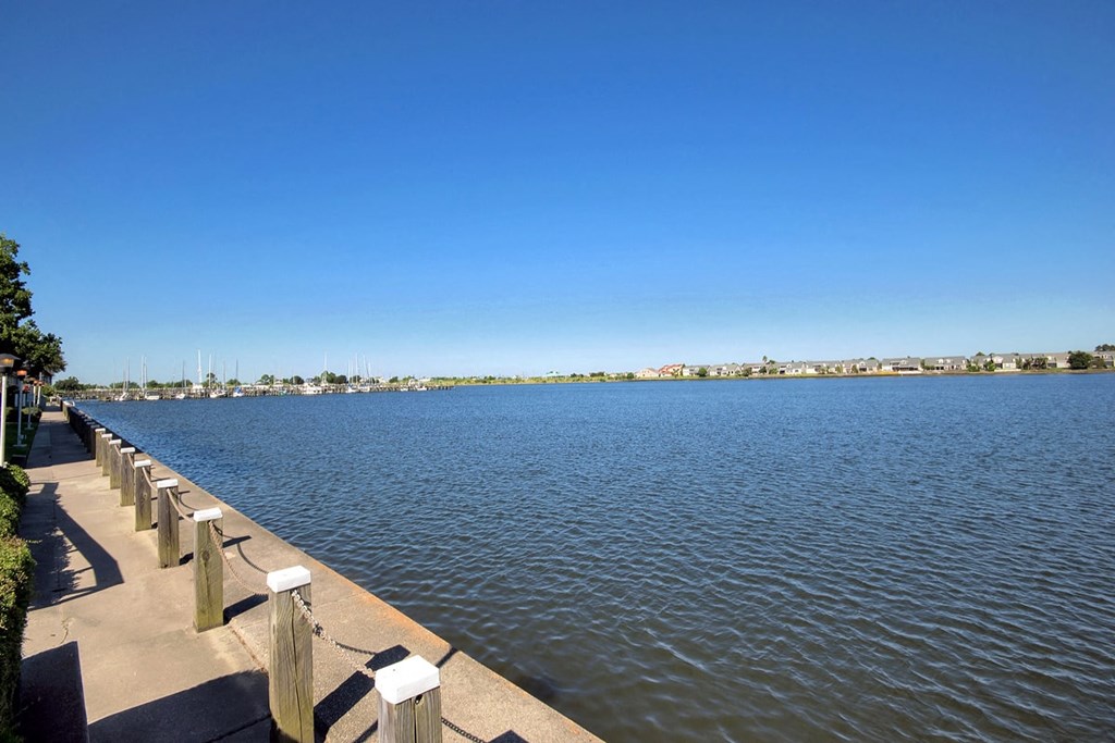 A long walkway runs along the side of a large body of water.